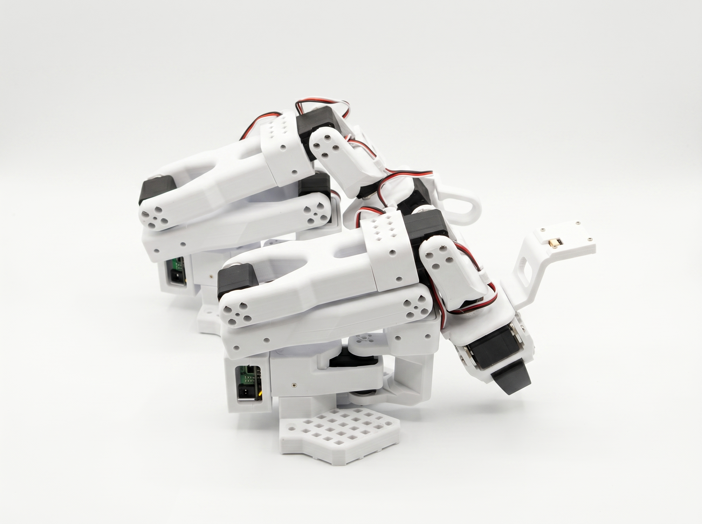 Two white SO-101 robot arms with grippers and serial-bus wiring