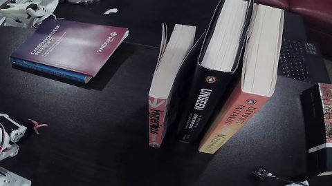 Books arranged upright for a robot pick-and-place skill